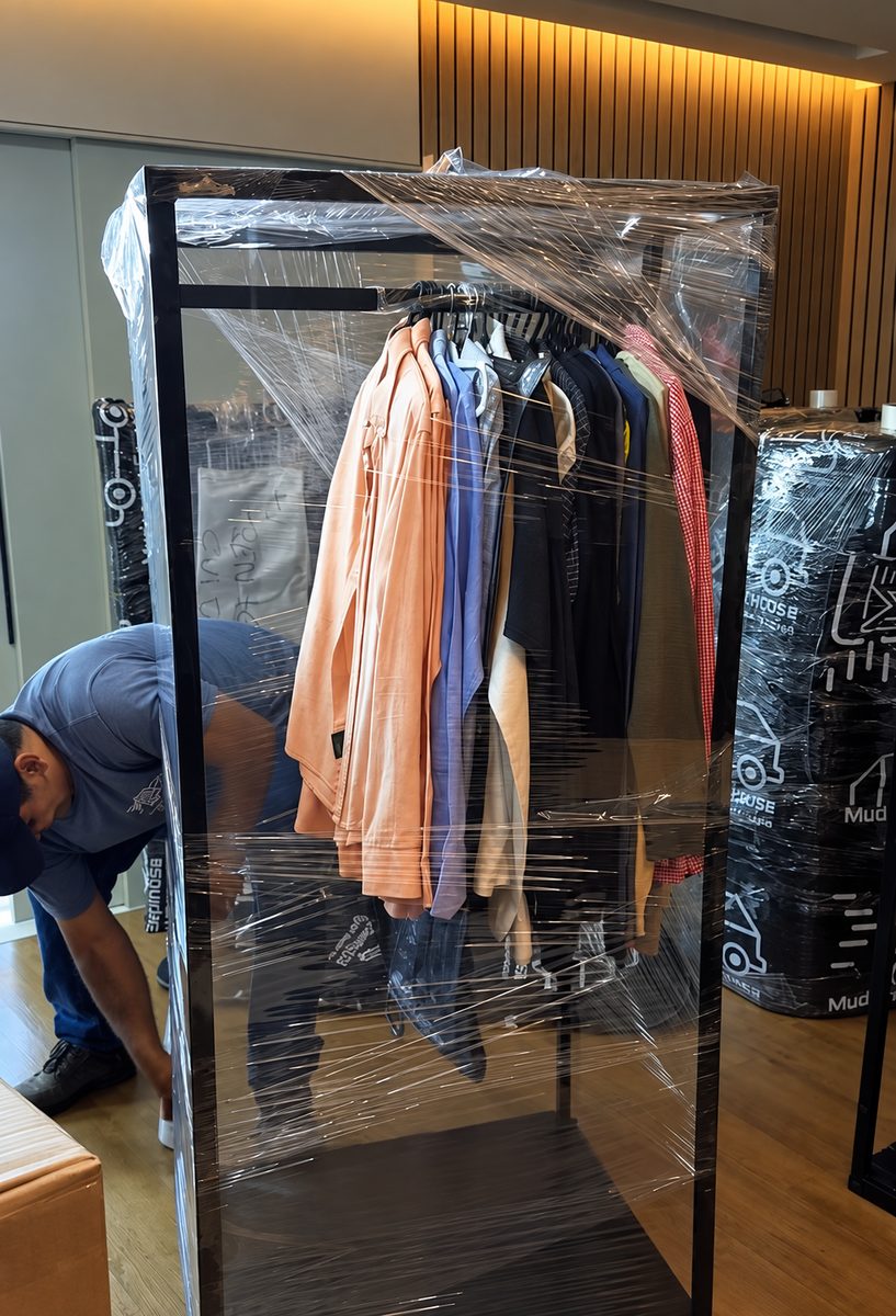Arara com roupas no cabide embalada em filme stretch para mudança de apartamento