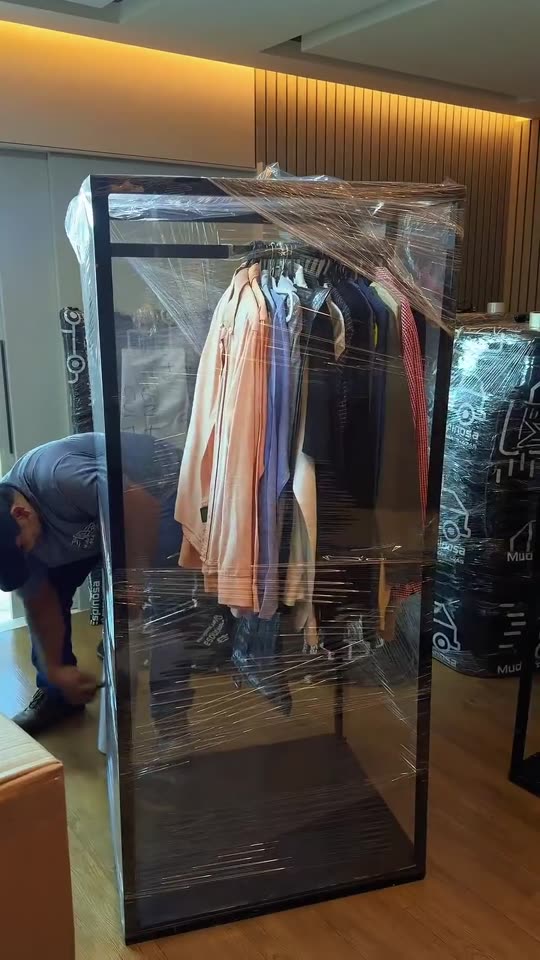 Arara de roupas lacrada com filme stretch entrando no caminhão de mudança